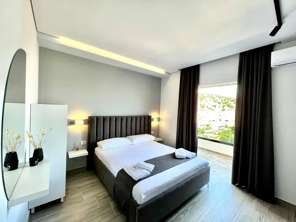 Deluxe Double Room with Sea View showing the double bed and bright balcony