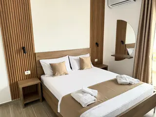 Deluxe Double Room with Balcony showing the full bed and modern wood interior — thumbnail